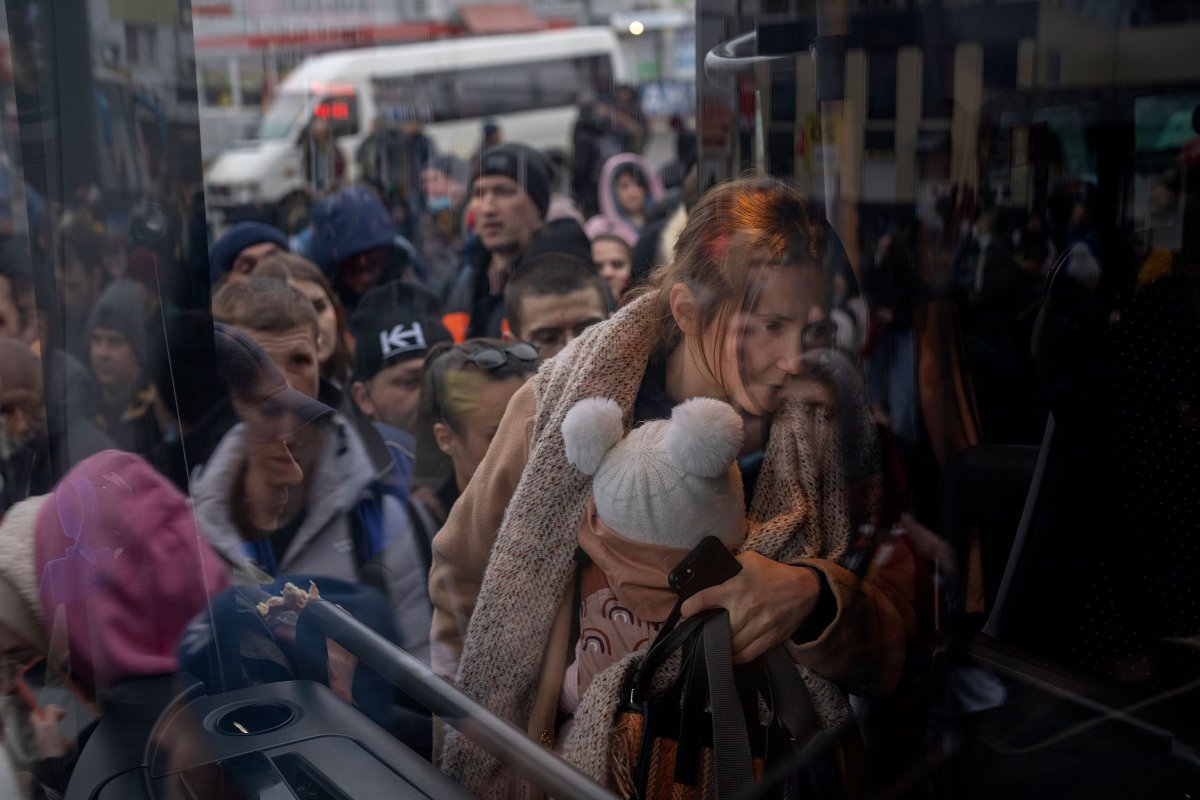 Μητέρα κρατώντας το παιδί της επιβιβάζεται σε λεωφορείο για να φύγει από το Κίεβο στις 24 Φλεβάρη (Φωτογραφία: Emilio Morenatti—Associated Press)